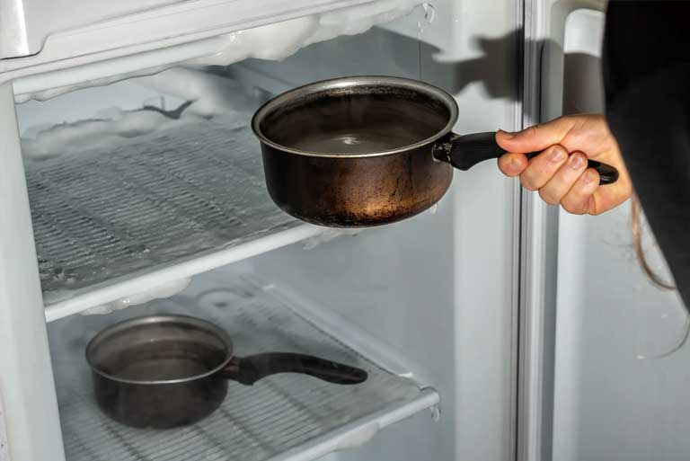 Descongelar el congelador con ollas calientes